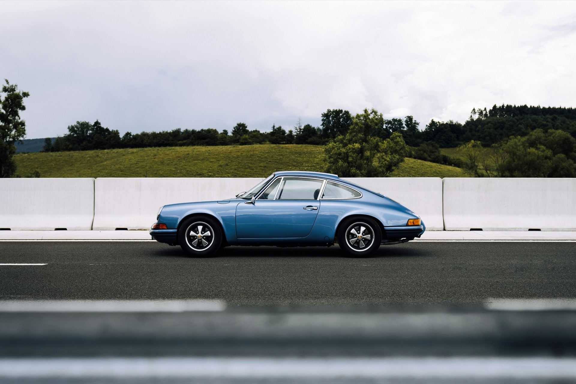 Porsche 911 bleue de profil sur route